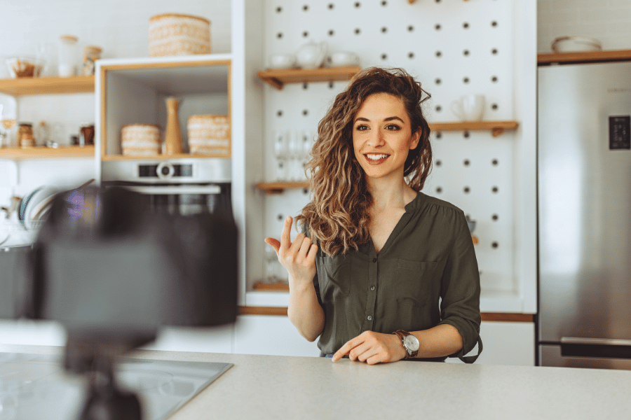 real estate agent filming an introduction video in a kitchen at the counter