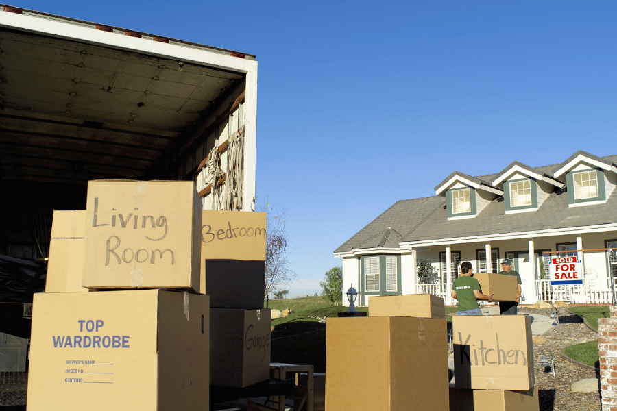 family moving to a new home and packing up moving truck with moving boxes