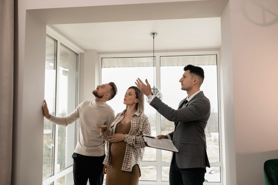 real estate agent conducting an open house and showing the home to two visitors