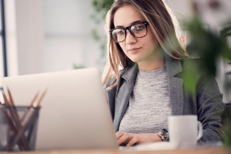 real estate agent wearing glasses working on the computer and developing targeted marketing messages for real estate clients