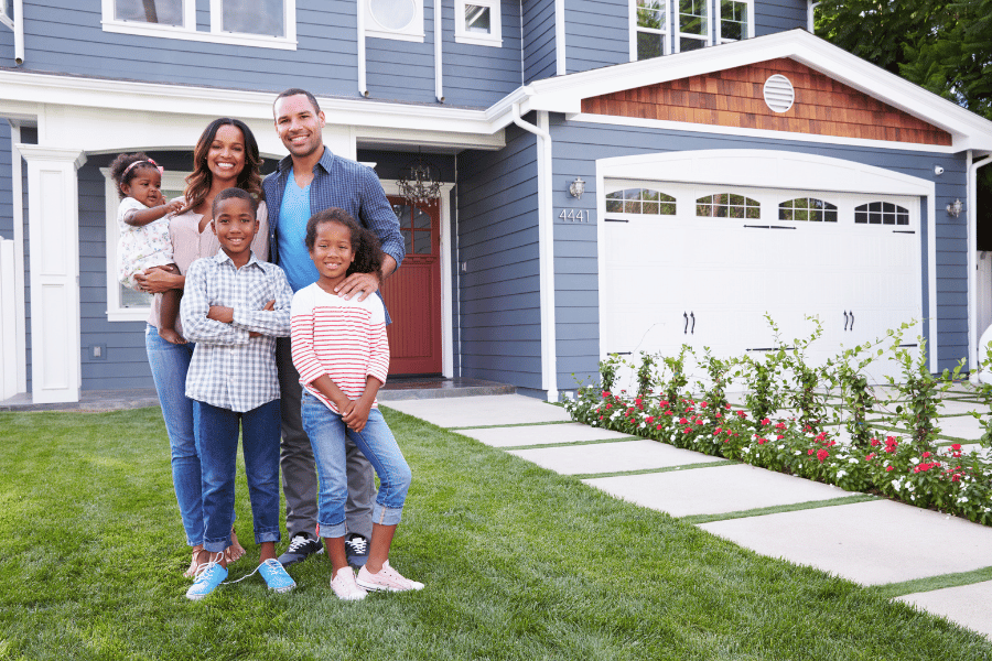 family of five standing in front of a new home that they bought with a part-time real estate agent