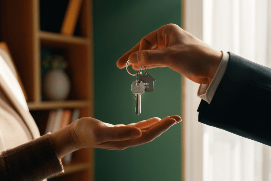 Real estate agent handing over the keys to a new home to a happy homebuyer