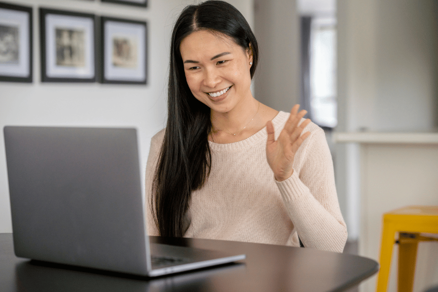 real estate agent hosting a virtual event online and waving at the computer