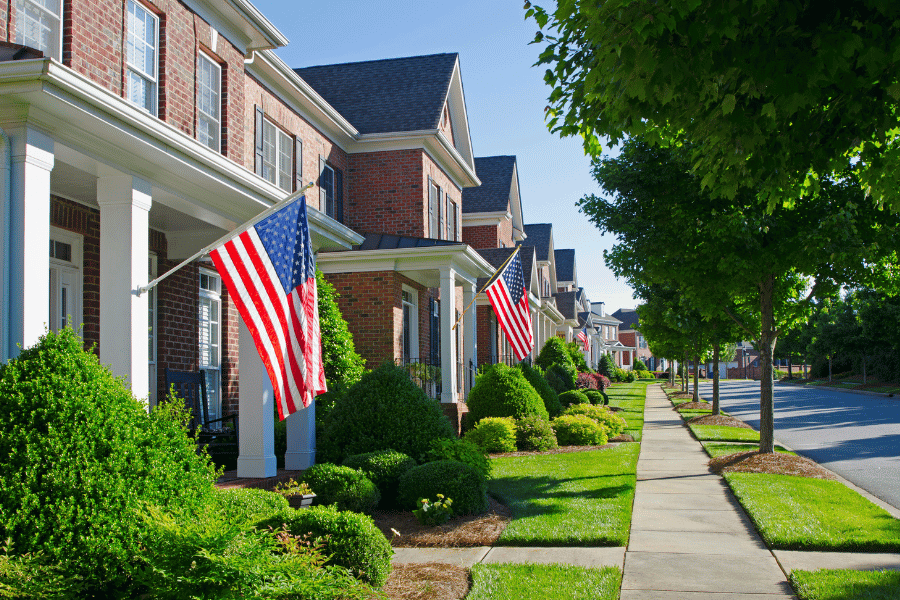 beautiful neighborhood full of large brick homes with front porches and American flags