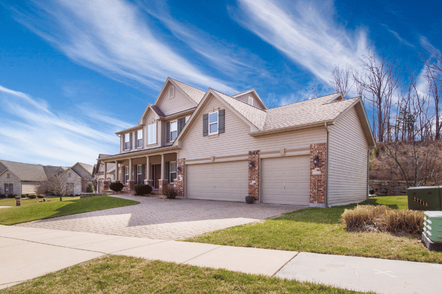 single-family home with two garages and large driveway.