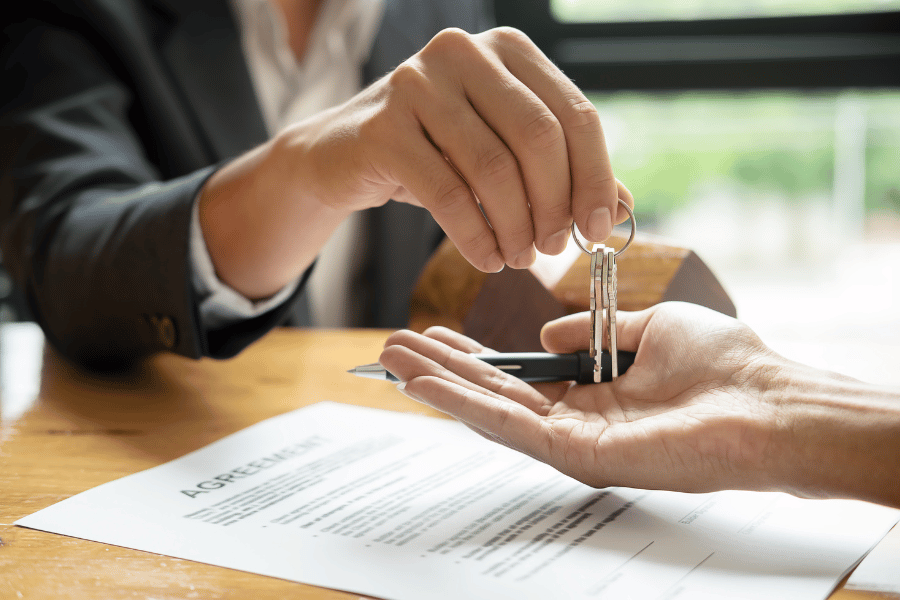 real estate agent handing over the keys to a new home to a buyer