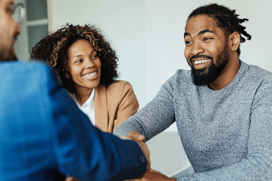 real estate agent collecting feedback from clients and shaking hands