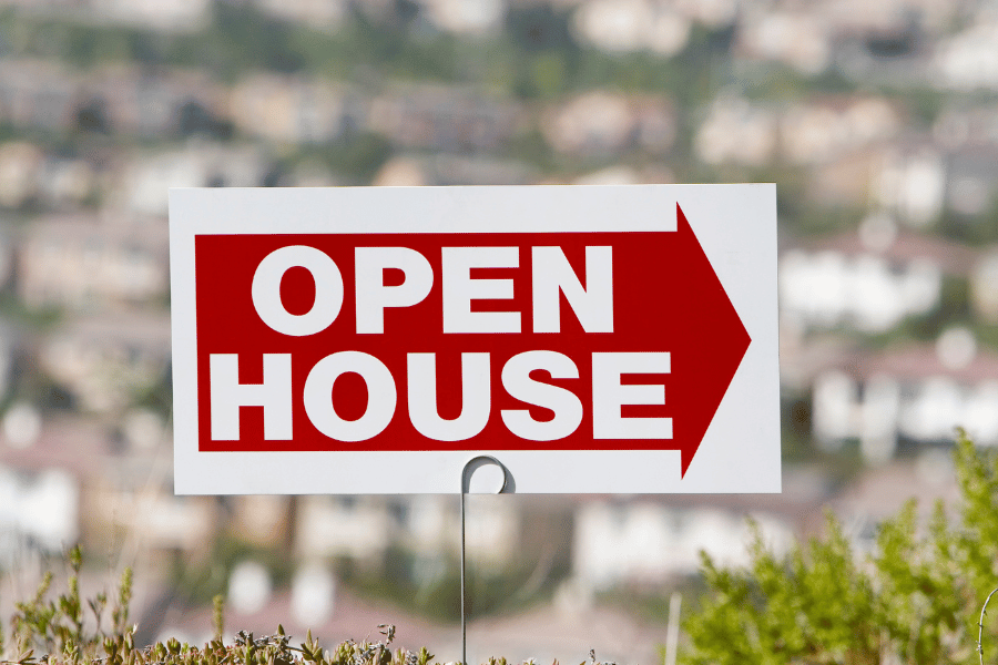 red and white open house sign in the ground outside