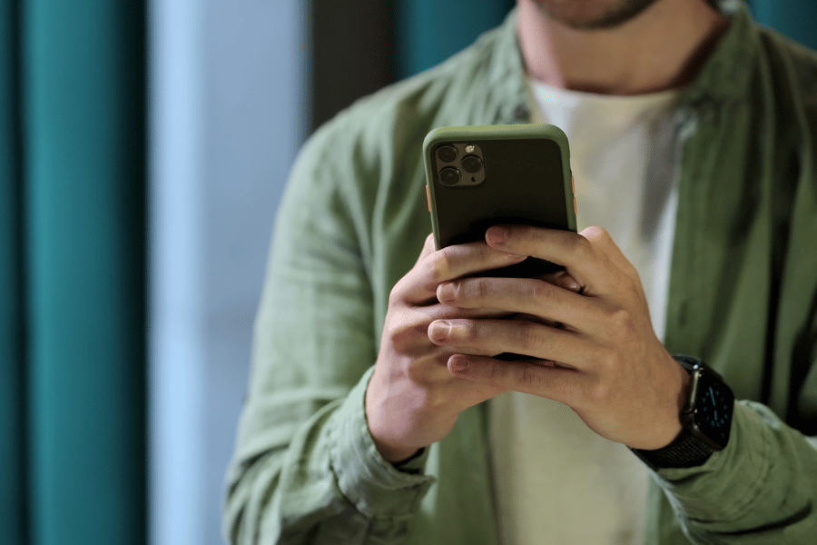 social media user in a green shirt on their phone